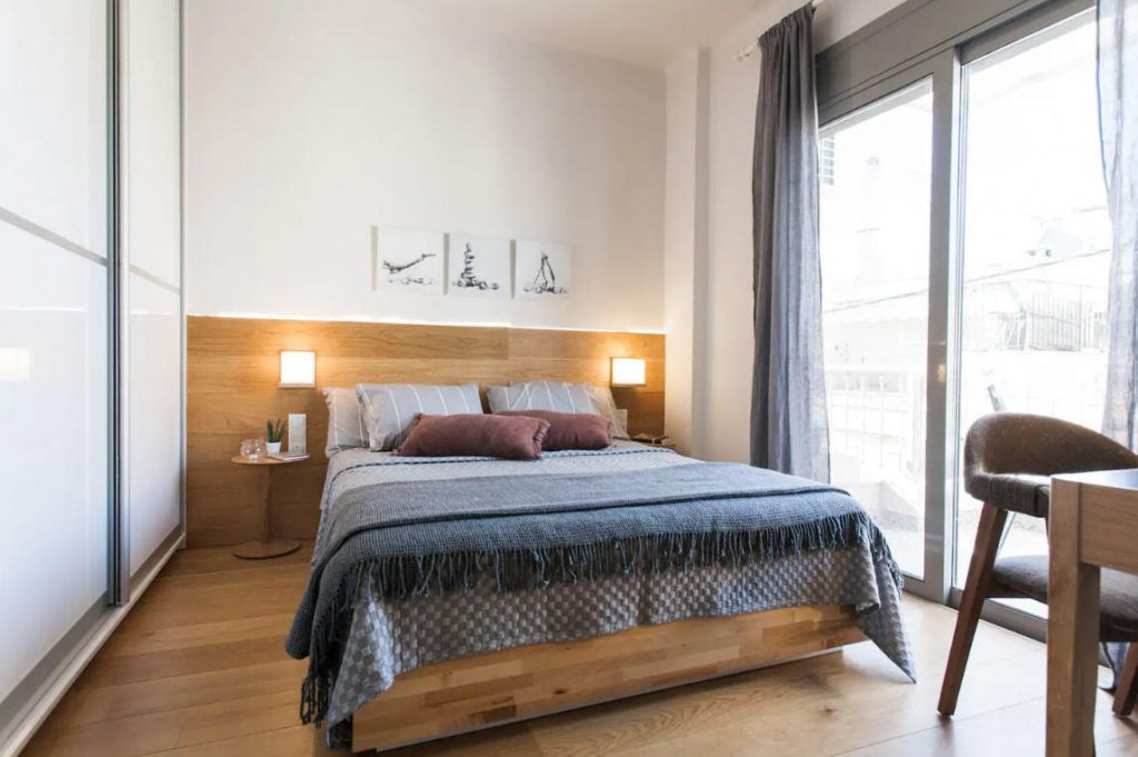 clean and simplistic bedroom with doors to balcony inside The Cutest Airbnb Vacation Rental In Athens, Greece