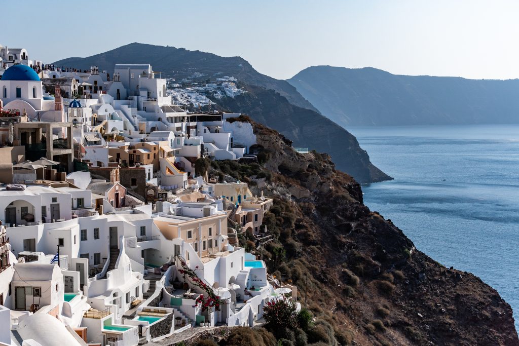 cliffside of oia santorini, greece with white washed houses overlooking the ocean