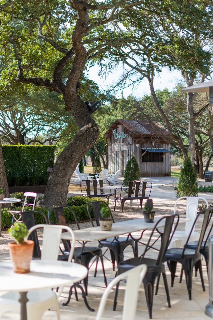 outdoor patio with table and chairs and wine barn outside of Signor Vineyards in Fredericksburg, TX