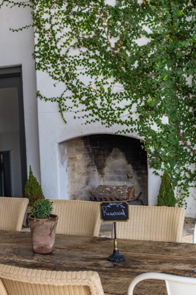 outdoor table and chairs with reserved sign and ivory covered chimney at signor vineyards winery in fredericksburg, texas