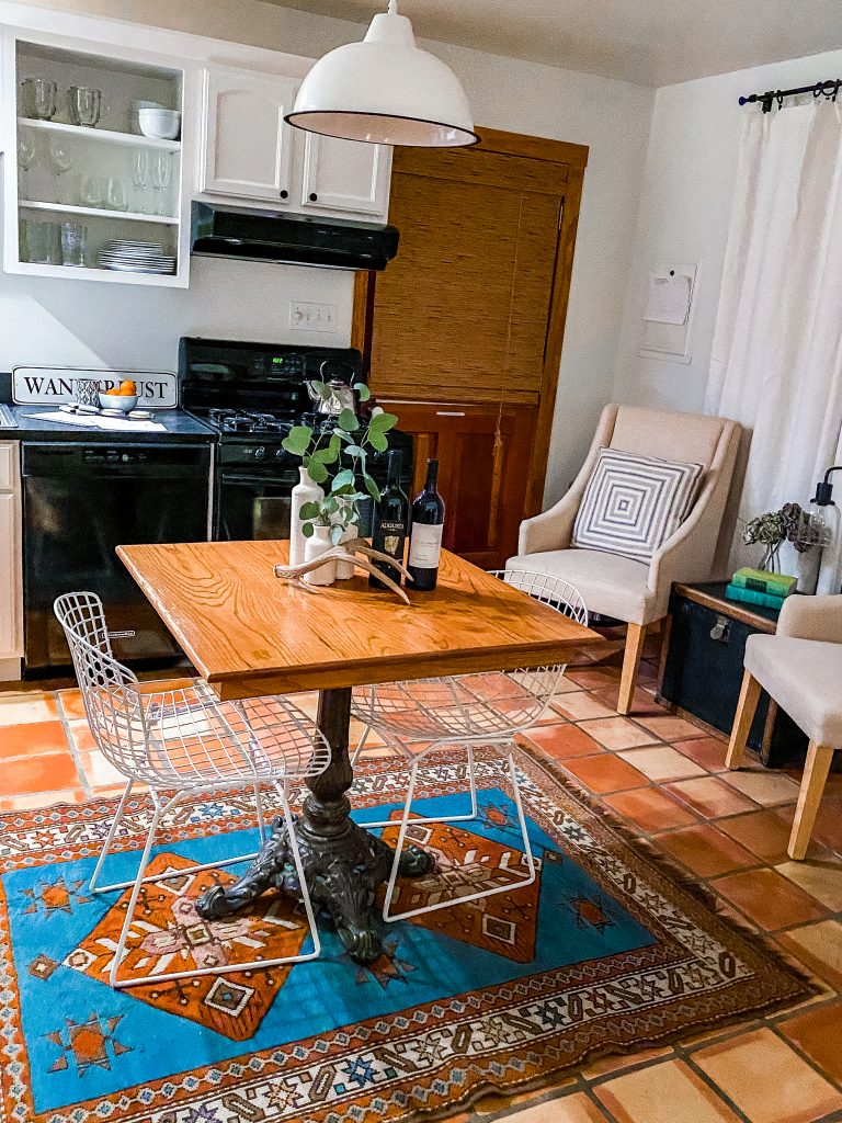 kitchen and table in emma haus fredericksburg with moroccan rug and extra chairs for seating, charming kitchen in emma haus fredericksburg cottage rental in texas hill country