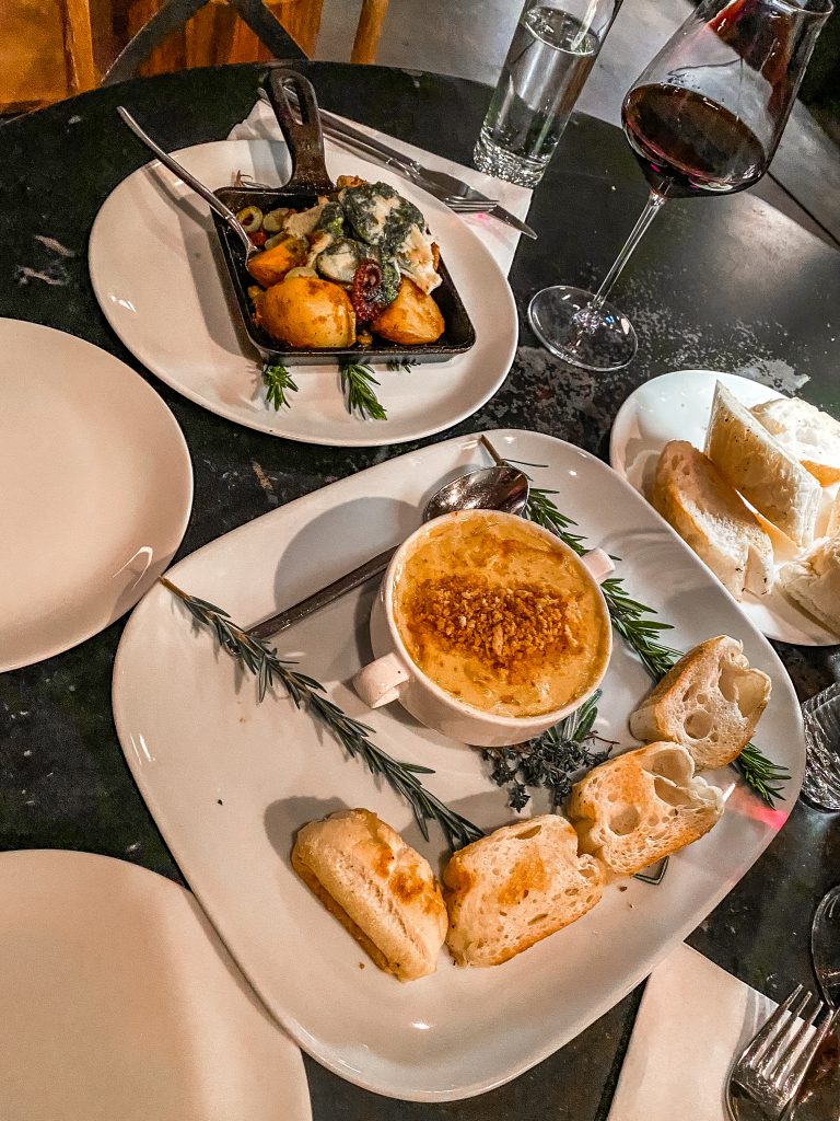 Seafood Gratin at Vaudeville Bistro in fredericksburg texas with Jumbo lump crab, gulf shrimp, buttered leek, artichoke oven baked with saffron bechamel & served with warm french bread