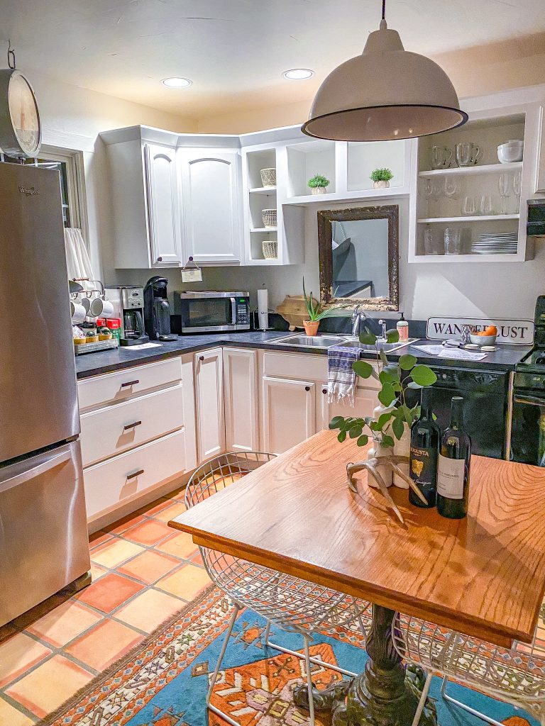 fully stocked kitchen and table in emma haus fredericksburg with moroccan rug and extra chairs for seating, charming kitchen in emma haus fredericksburg cottage rental in texas hill country