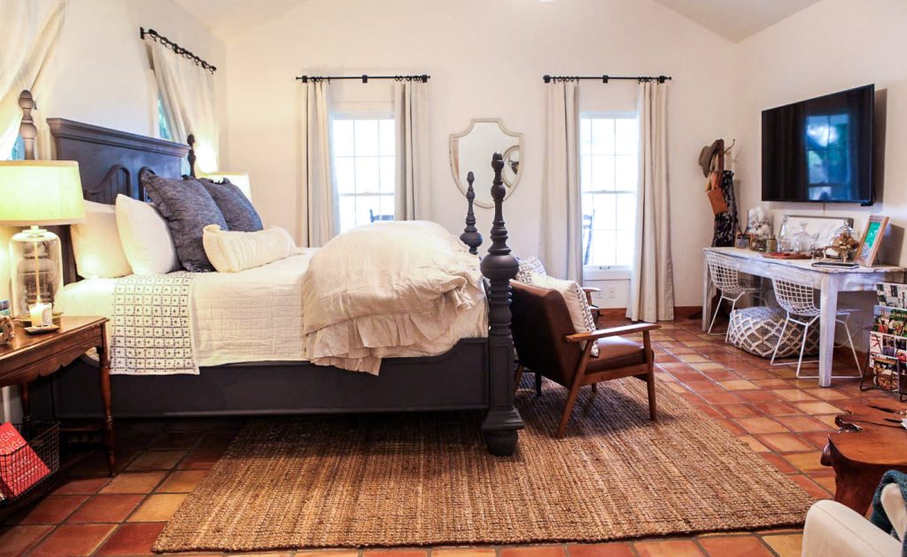 master bedroom with king size bed and decor in emma haus fredericksburg luxury vacation rental, airbnb rental in fredericksburg tx, charming rental in texas hill country