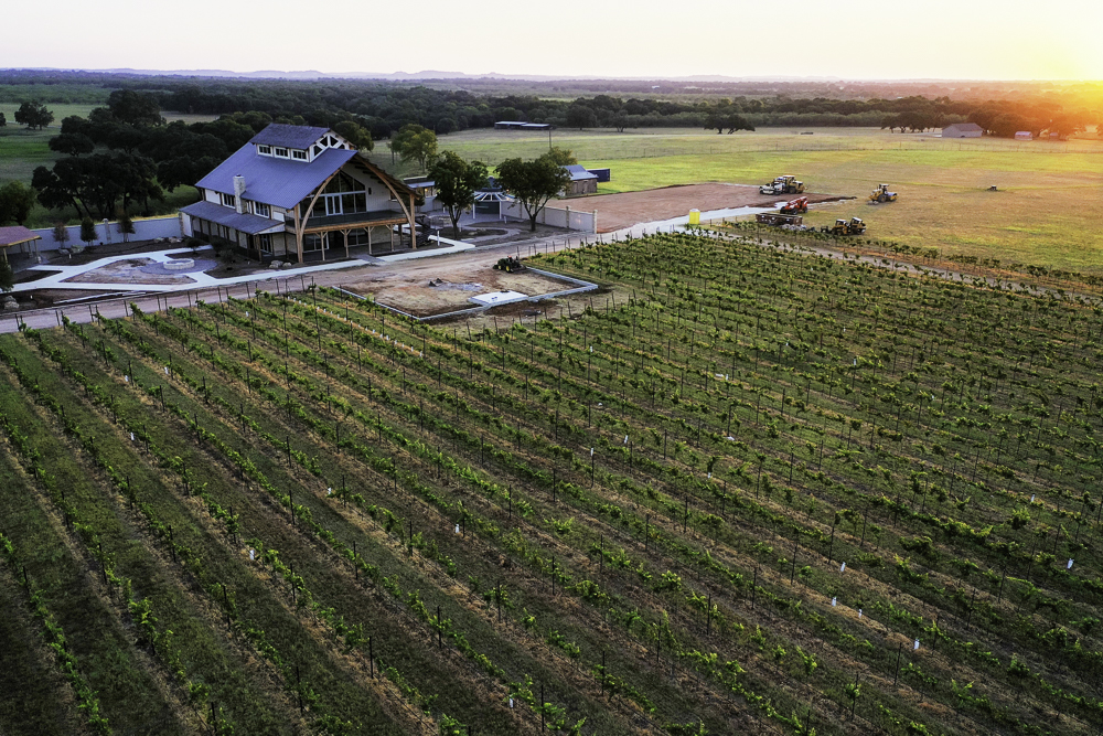 augusta vin winery fredericksburg, texas, augusta vin estate winery in texas hill country, Augusta Vin property with large balcony patio overlooking vineyards, beautiful vineyards and rolling hill landscape surrounding augusta vin winery in fredericksburg tx