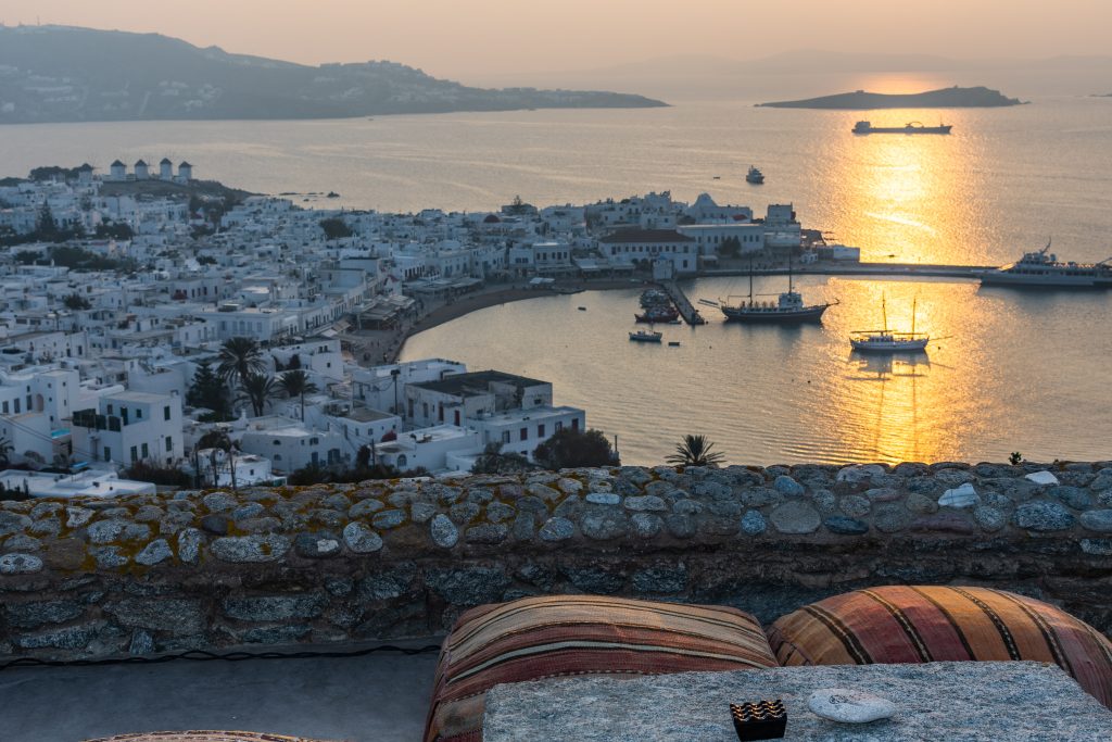 sunset view from 180° Sunset Bar in Mykonos Greece overlooking Mykonos Town and the windmills. Where to watch the sunset in mykonos, the best things to do in mykonos greece