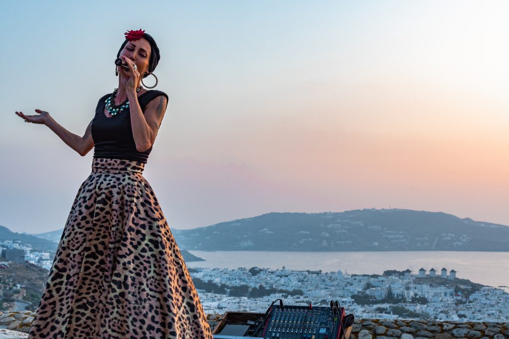 live music entertainment with sunset view at 180° Sunset Bar in Mykonos Greece overlooking Mykonos Town and the windmills. Where to watch the sunset in mykonos, the best things to do in mykonos greece