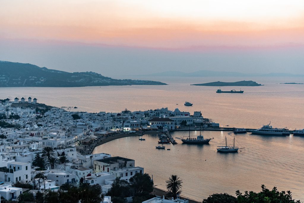 sunset view from 180° Sunset Bar in Mykonos Greece overlooking Mykonos Town and the windmills. Where to watch the sunset in mykonos, the best things to do in mykonos greece