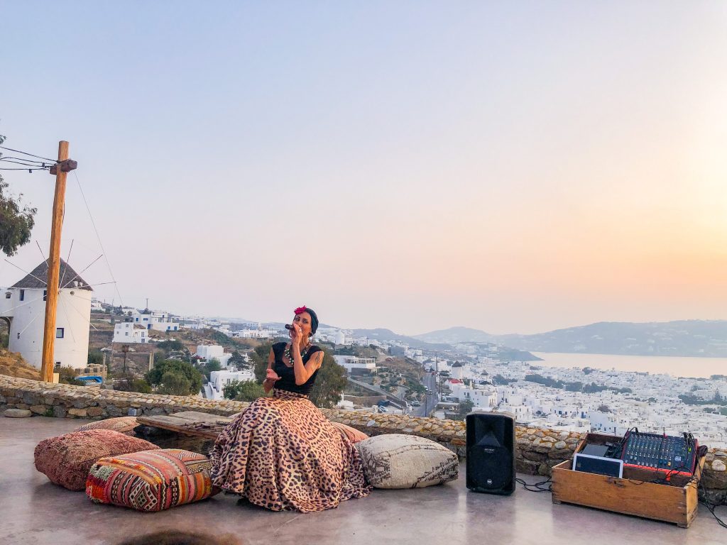 live music entertainment with sunset view at 180° Sunset Bar in Mykonos Greece overlooking Mykonos Town and the windmills. Where to watch the sunset in mykonos, the best things to do in mykonos greece