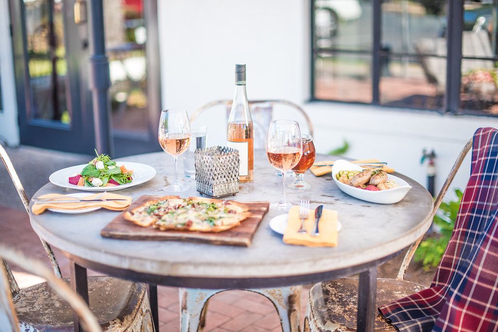 outdoor dining table at otto's german bistro in fredericksburg, lunch at otto's restaurant in fredericksburg with rosé wine, pizza and salads for lunch